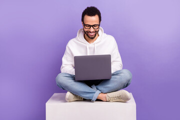Full length photo of stylish wear latin man coder freelancer found new coworking zone sit platform place isolated on purple color background