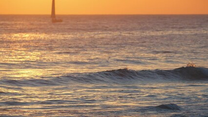 Wall Mural - beautiful evening sunset with a big sun and a sailing yacht in the atlantic ocean on the coast of po