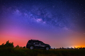 Black camp car at night  with many stars before sunrise. Space background with noise and grain. Night landscape with car and colorful bright milky way.Beautiful scene with universe. 