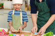 © Stella - Happy smiling Asian father and son kid with apron and chef hat cooking meal together at kitchen, dad parent and boy child cutting bread into various shapes with cutters, cute family chef cooking food.