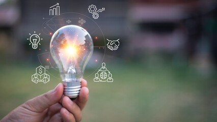 holding a bright light bulb. Concept of Ideas for presenting new ideas Great inspiration and innovation new beginning.Green background