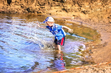 Wall Mural - Boy splashes water in the river, Gorokhovets