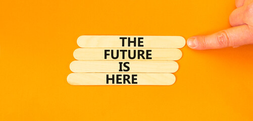 Wall Mural - The future is here symbol. Concept words The future is here on wooden stick. Beautiful orange table orange background. Businessman hand. Motivational business the future is here concept. Copy space.