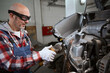 © Viacheslav Yakobchuk - Auto mechanic in goggles uses pneumatic cutter