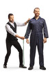 Tailor measuring a male overall uniform for a worker