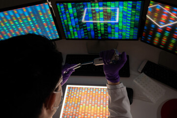 Male researcher in front of genome screens.