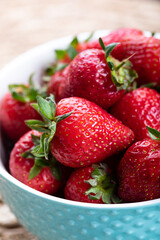 fresh strawberries in a blue bowl on a table. fresh ripe delicious strawberries in a bowl. close-up.