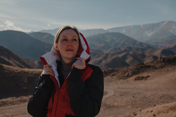 Poster - Portrait of young woman tourist on mountain background in autumn