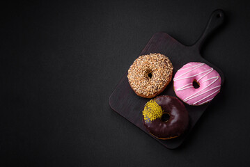 Delicious donut with cream filling and nuts on a dark concrete background