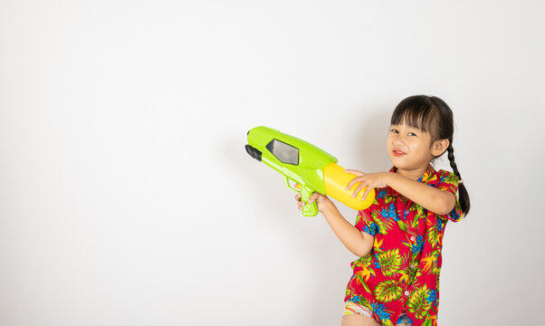 happy songkran day, asian kid girl with floral shirt hold water gun, thai child funny hold toy water