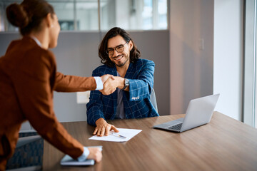 Happy businessman greeting his female college in office.