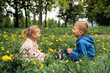 © kieferpix - Cute little boy and girl, brother sister laughing playing in a meadow field with wild spring flowers