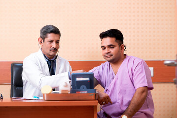 Wall Mural - Doctor check up to young patient blood pressure at clinic.