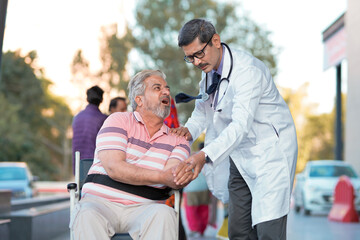 Wall Mural - Doctor checking to old man while he is moaning in pain.