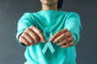 Close-up teal awareness ribbon holded by woman hands to support cancer survivor. Ovarian Cancer month, cervical cancer day. 