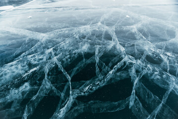 The space magical deep Baikal ice with cracks before your eyes. Close-up view