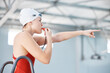 Swimming pool, lifeguard and woman blowing whistle with goggles for safety training exercise at club. Professional water sports, life saving workout and swimmer at swim competition with attention