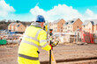 © Iryna - Surveyor builder site engineer with theodolite total station at construction site outdoors during surveying work