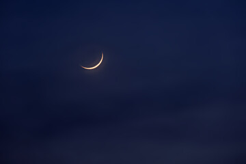 new moon in the initial phase on a dark night sky