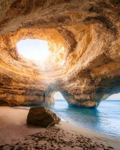 Vertical Shot Of A Person Standing On The Rock, Benagil Cave In Algarve, Portugal