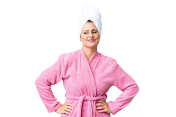 Canvas Print - Middle age caucasian woman in a bathrobe over isolated background posing with arms at hip and smiling