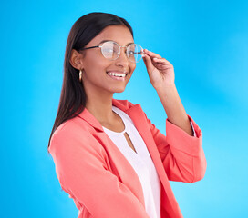 Sticker - Woman, glasses and happy portrait in studio with a smile for eye care and vision with frame or lens. Smile of Indian female model person on a blue background with specs for fashion and business