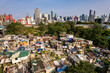 Metro Manila, Philippines - A squatter colony contrasts with the modern BGC skyline. Concept of inequality.