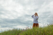 © Minakryn Ruslan  - beautiful girl in white shirt and orange skirt against blue sky and clouds