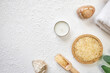 © Inna Vlasova - Spa treatment concept. Natural spa cosmetics products, sea salt, sea stone, massage brush, towel on white textured background from above. Spa background with a space for a text, flat lay, top view