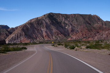 Wall Mural - View of the empty road across the arid desert and sandstone mountains. 