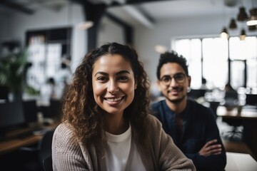 Young business colleagues in modern office smiling directly at the camera