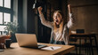 © bahadirbermekphoto - Excited young woman sitting at table with laptop and celebrating success