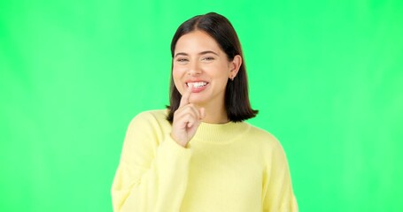 Wall Mural - Green screen, happy face and secret woman with finger on lips, wink and privacy in studio. Portrait of female model, silence and shush for quiet, gossip and whisper emoji for confidential surprise