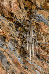 Hanging icicles on an alpine rock formation in Austria during winter