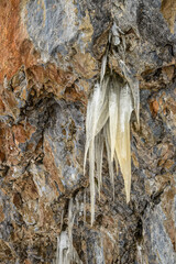 Frozen icicles hanging from an alpine rock