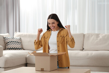 Sticker - Emotional young woman opening parcel at home. Internet shopping