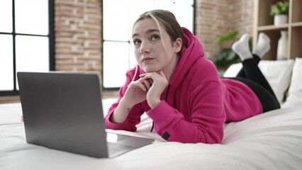 Sticker - Young blonde woman using laptop lying on bed at bedroom