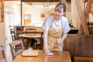 アルコール消毒で除菌・コロナ対策している飲食店・カフェのスタッフ
