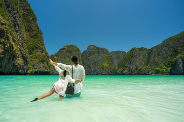 asian child summer or kid girl raising arms in clear sea water and blue sky to mother daughter by family happy on maya bay beach with mountain for tourist vacation travel on holiday at krabi thailand