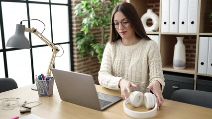 Poster - Young beautiful hispanic woman business worker using laptop and headphones working at office