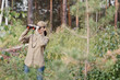 © junky_jess - A woman forester in uniform looks through binoculars and monitoring the forest area in summer, selective focus.
