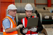 © eakgrungenerd - Two man industrial engineers wear hard hats and uniform using laptop talking project of factory inside heavy industry manufacturing. Supervisor teaching work to employee.