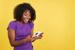 © Iván Moreno - Happy woman with afro hair smiling while reading a mobile