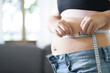 © Charlie's - Obese Woman with fat belly in dieting concept. Overweight woman touching his fat belly and want to lose weight. Fat woman her waist with a centimeter..Shape up healthy stomach
