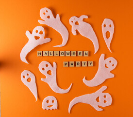 Wall Mural - White ghosts craft for Halloween party. Wrapping paper ghost on orange background top view. Cartoon creepy Whisper. DIY hand made. Set boo characters. Word wooden letter phrase.