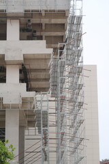 Scaffolding on multi storey building facade during facade renovation. Bright sunny day.