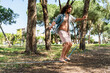 © blackday - Young man slacklining in the city park during summer day