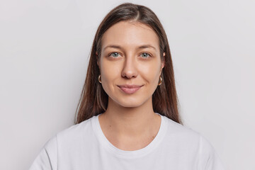 portrait of good looking brunette woman with natural eauty healthy skin straight hair looks directly