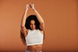 © Flamingo Images - Young black woman dancing in front of an orange background