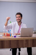 © Elnur - Young male chemistry teacher sitting in the classroom